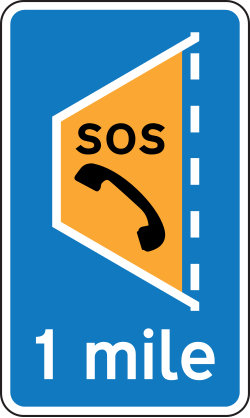UK blue sign giving advance warning of an emergency area 1 mile ahead, with an orange SOS telephone symbol