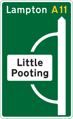 UK primary route advance direction sign for a junction ahead, including a separate route into a by-passed town or village
