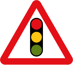 UK traffic signals ahead warning sign: a red-bordered triangle with a traffic light symbol showing red, amber and green