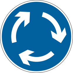 UK mini-roundabout sign: a blue circle with three white curved arrows forming a circle