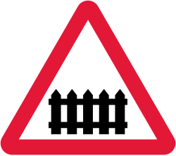 UK level crossing with barrier or gate ahead warning sign: a red-bordered triangle with a black gate symbol